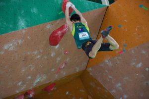 Jun Park clings to a hold with both hands in a national climbing competition.